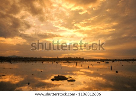dramatic gold summer sunset over Nong Han lake, Sakon Nakhon, Thailand.