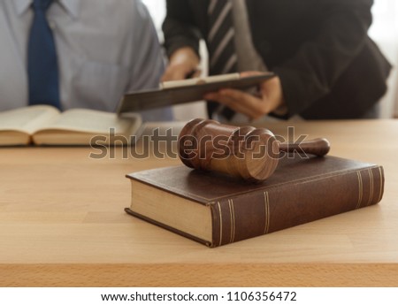 law,legal,legislation concept. judge hammer on legal book with lawyer and attorney consult in legal office.