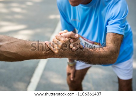 Senior runner giving a helping hand Royalty-Free Stock Photo #1106361437