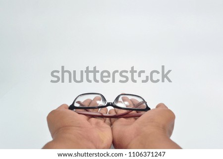Two hand gestures giving black and red glasses isolated on white
