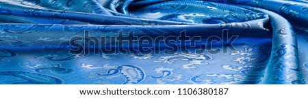 The texture of the silk fabric. Dark blue. With a picture of cucumbers. a fine, strong, soft, lustrous fiber produced by silkworms in making cocoons and collected to make thread and fabric