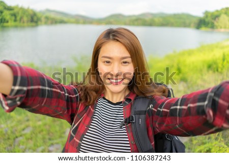 Travel Vacationing Tourist Selfie,Asian Woman taking self-portrait photo in lake forest with smartphone, Young Girl on summer vacation visiting famous tourists destination have fun smiling to camera 