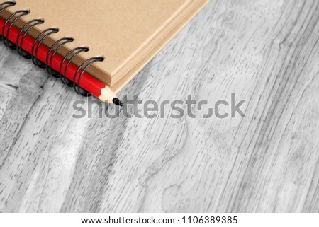 Black and white of photo an old memory book with red pencilon wooden table, Top view of the notebook or diary book with with pencil on table, Memories or Romance concept with copy space
