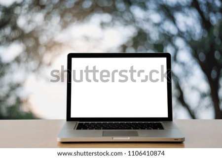 Workspace wooden desk on Laptop with blank screen and wireless mouse and graphics tablet and notebook,at Natural blurred background of light bokeh.