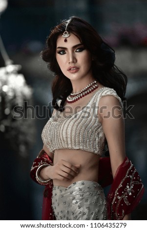 Portrait of beautiful indian girl. Young hindu woman model with tatoo mehndi and kundan jewelry. Traditional Indian costume lehenga choli .