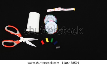 Closeup top view of sewing tools  accessories on  black fabric texture background for your design works