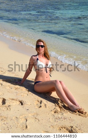 young girl is traveling by the sea in summer and is resting on the beach.