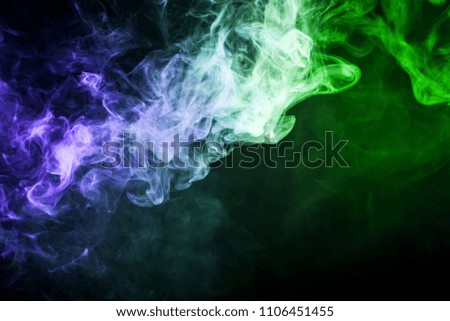 Dense multicolored smoke of   blue and  green colors on a black isolated background. Background of smoke vape
