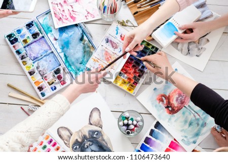 creative leisure. painting hobby. artful personalities working together. watercolors and drawings scattered on the table