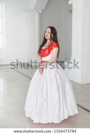 Beautiful woman in white and red medieval dress with crinoline in the hall