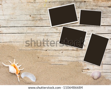 Sand and photographs on planked wood. Summer background with copy space. Top view