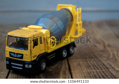 yellow toy concrete mixer on a wooden background