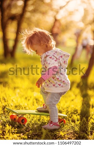 Funny baby with a skate in a Sunny Park.