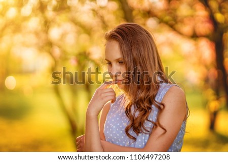 Portrait of a beautiful smiling girl with beautiful long hair in spring garden.