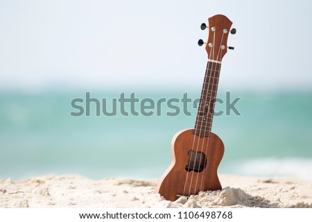 Guitar ukulele on sand beach with clear water and blue sky. The beautiful summer beach wiht copy space. Music make a happy and luxury in holiday summer background. Travel and lifestyle Concept.
 Royalty-Free Stock Photo #1106498768