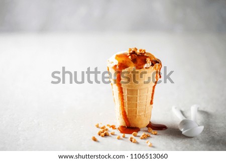 Ice cream in a wafer cup on a light stone background. Selective focus