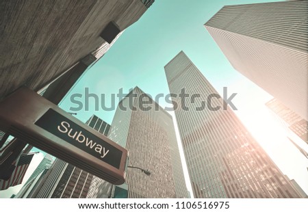 Looking up at subway entrance sign and New York skyscrapers at sunset, color toned picture, USA.