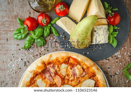 Appetizing Hawaiian pizza with a pear on wooden background, top view