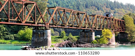 The now abandoned warren through truss swing span bridge over the Skagit River in Skagit County, Washington, USA. Royalty-Free Stock Photo #110653280