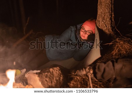 Traveler woman sitting near campfire