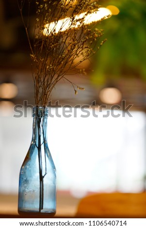 Photography of a glass bottle in a cozy warm interior. 