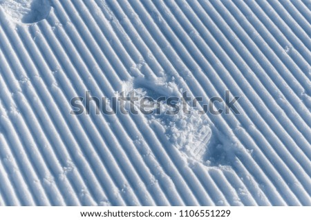The snow Gudauri in Caucasian mountains. Footprints on an snow slope.