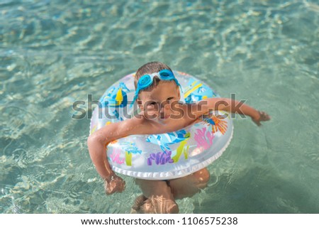 Boy with inflantable ring swimming in sea