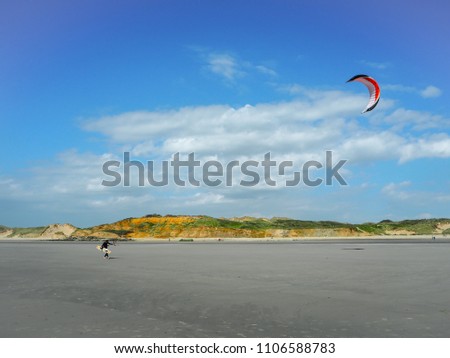 Kitesurfers walking back to the beach at Pointe aux oies coastline near Wimereux in the French Opal coast, famous for kitesurfing