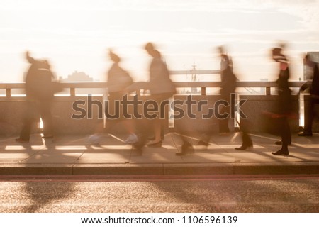 City commuters. High key blurred image of workers on London Bridge at sunrise. Unrecognizable faces. London, UK. 