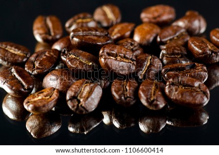 Dried coffee beans on black background.