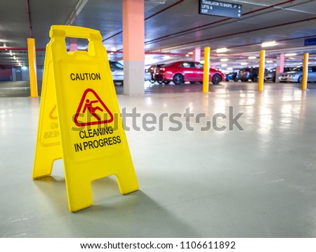Warning janitorial sign of cleaning in progress in car park to warn passersby for safety.