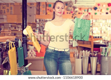 Glad woman demonstrates multi colored and other gift bags