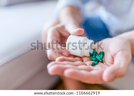 Senior man taking pills, closeup. Many pills from a glass bottle in the Senior hands. Caring for the health of the elderly. Health issues at an old age, taking several medicines. Royalty-Free Stock Photo #1106662919