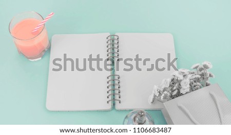 Banner Open notebook for records lies on the surface of the cocktail pink glass tube bouquet of chrysanthemums. The pastel blue background copy space