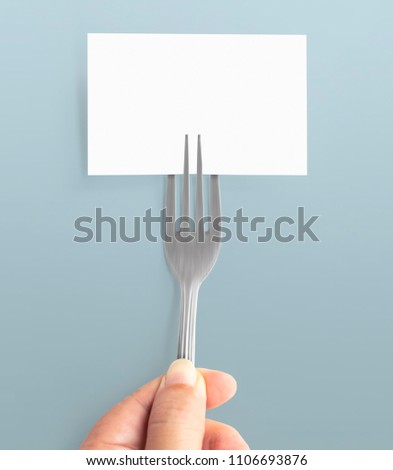 Blank paper mock up card and hand holding of fork. Creative layout for business food concept. With clipping path.