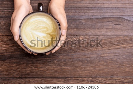 The hand of a woman holding a coffee