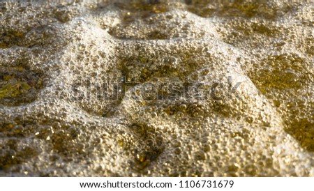 Foams of soft wave on blue sea or ocean on sandy beach. Background. Selective focus. Wallpaper.
