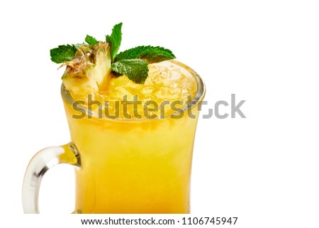 Closeup of a fresh tropical yellow pineapple cocktail in a glass cup, decorated with slices of pineapple and mint, isolated on a white background.