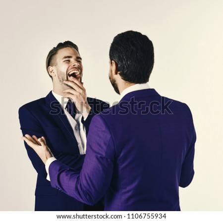 Business and friendship concept. Man in jacket listening his business partner and laughing. Successful negotiations between partners. Boss and employee speaking at meeting on light background.