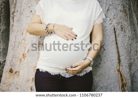 Pictures of the belly of pregnant women in nature with natural background and backlight at sunset