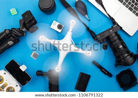 Digital camera with lenses,drone and equipment of the professional photographer on blue paper background
