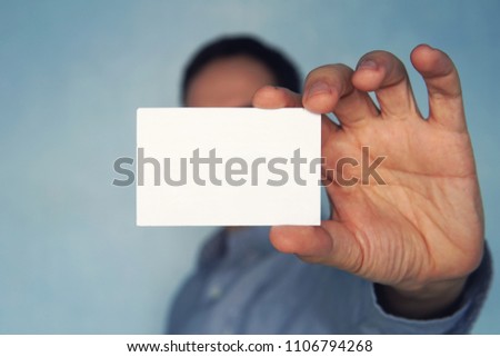 Bearded Man Wearing Casual Black Tshirt Showing Blank White Business Card.Blurred Background Ready Corporate Private Information. Horizontal Mockup