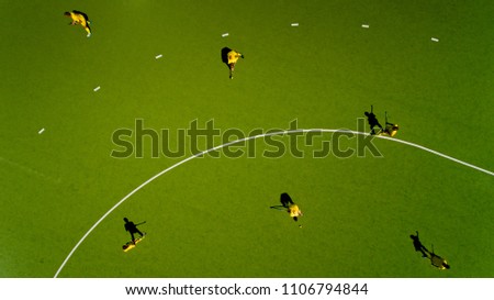 Aerial view of children playing hockey on the grass. Top view.
