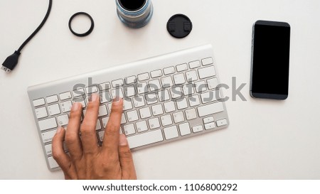 Top view of photographer work station with hand hold on white background