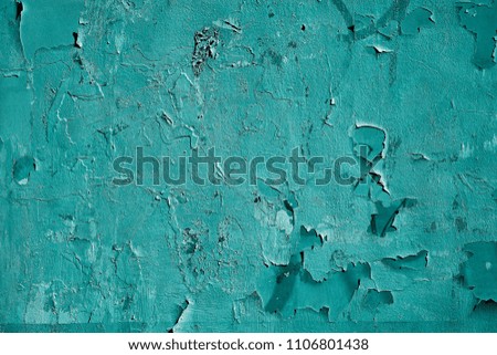 the textured abstract background of the damaged surface of the old plastered wall of blue green color