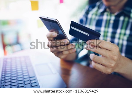 Man using mobile phone and laptop for shopping online by credit card. Pays for purchase.online shopping, online payment,buy and sell products & services. Royalty-Free Stock Photo #1106819429