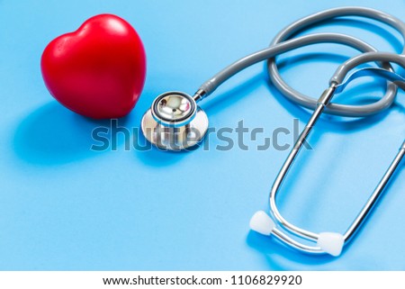 red rubber heart and stethoscope on blue background, health concept
