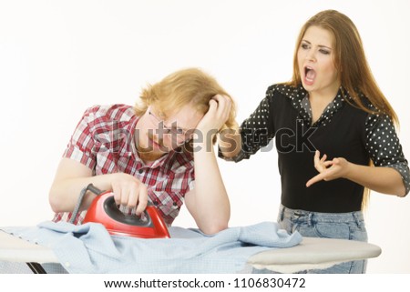 Woman trying to convince his man to do ironing, husband being bored and tired. Household domestic life problems.
