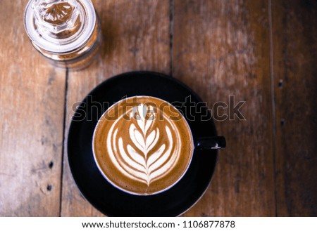 Cup of hot cappucino is on wooden table background with brown sugar