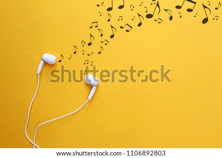 White earphones with music note on yellow background.